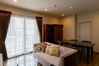 Spacious living room with modern furniture and large window offering natural light.
