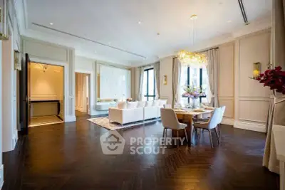 Luxurious open-plan living and dining area with elegant chandelier and hardwood floors
