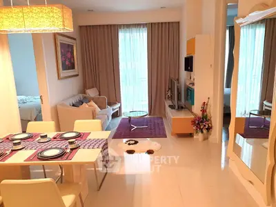 Modern living room with dining area, cozy seating, and elegant decor in a bright apartment.