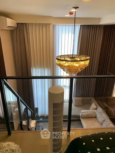 Luxurious living room with high ceilings, elegant chandelier, and modern decor in a stylish apartment.