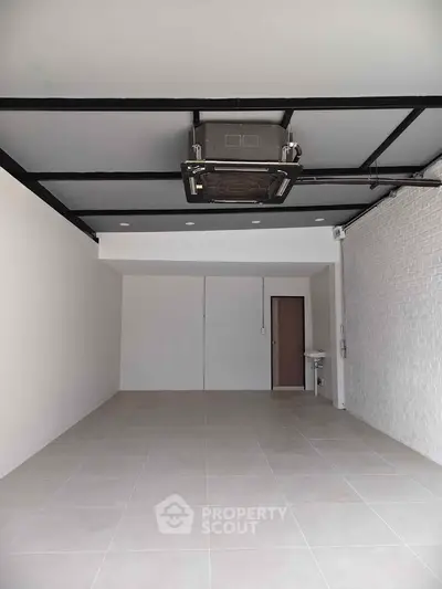 Spacious empty room with tiled flooring and modern ceiling design, ideal for versatile use.