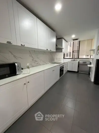 Spacious modern kitchen with sleek white cabinets and built-in appliances