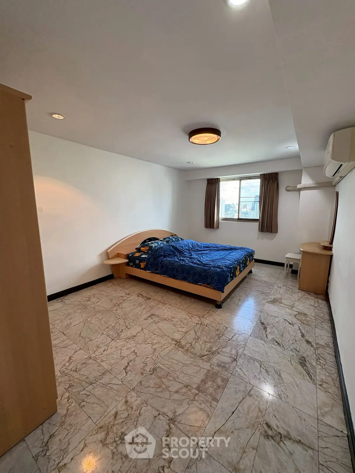 Spacious bedroom with marble flooring and modern furnishings