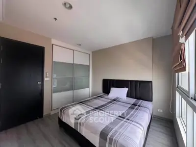 Modern bedroom with stylish decor and ample natural light in a contemporary apartment.