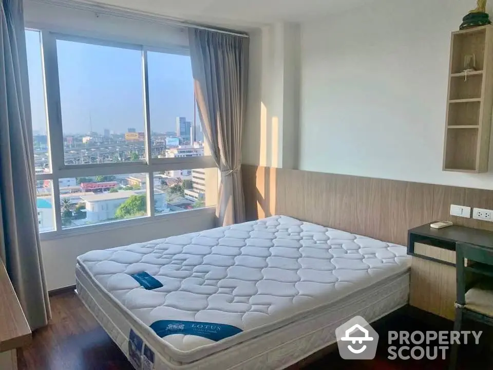 Bright bedroom with large window offering stunning city views and modern furnishings.