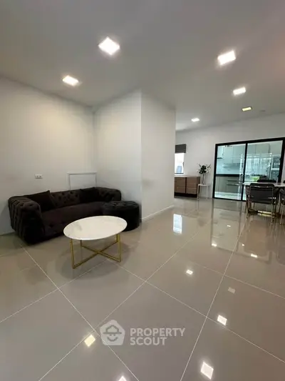 Spacious modern living room with elegant furniture and glossy tiled flooring.