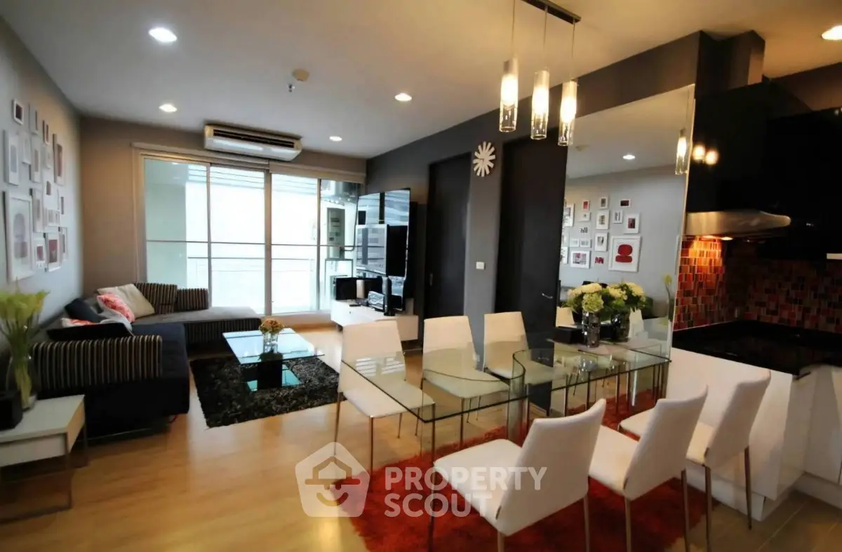 Modern living room with stylish decor, glass dining table, and cozy seating area.