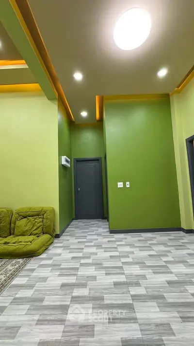 Modern living room with vibrant green walls and stylish ceiling lights