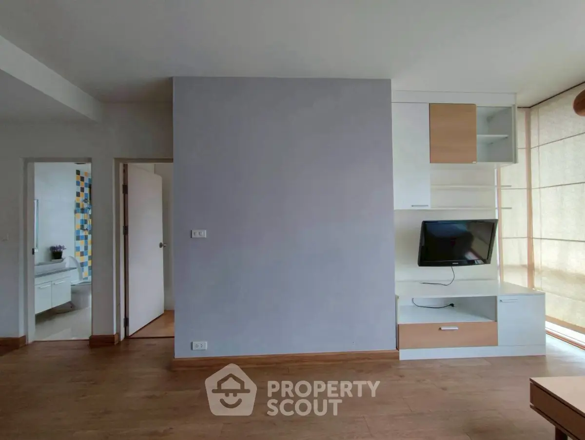 Modern living room with built-in TV unit and wooden flooring