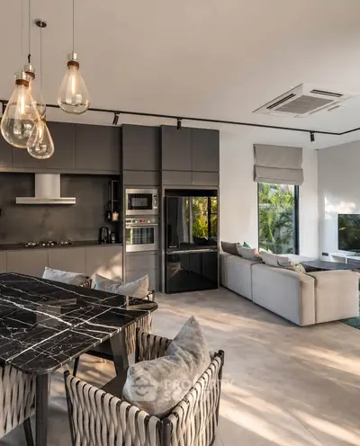 Luxurious modern living room with open kitchen, stylish lighting, and elegant decor.