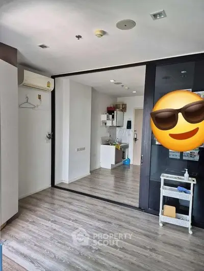 Modern apartment interior with sleek flooring and compact kitchen area.