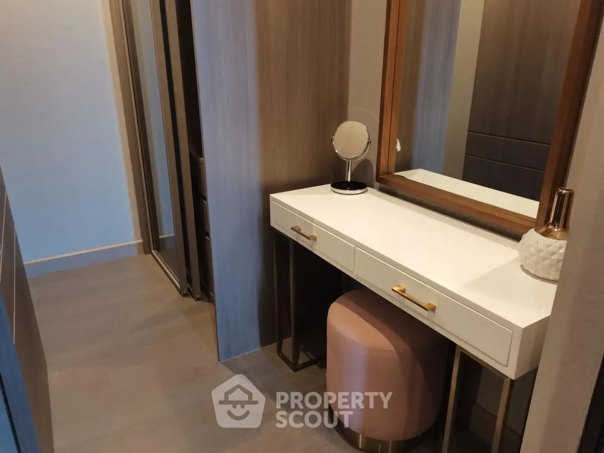 Elegant dressing area with modern vanity and mirror in stylish interior design.