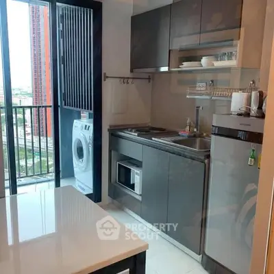 Modern compact kitchen with balcony view and washing machine