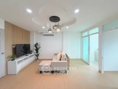 Modern living room with stylish ceiling lights and cozy sofa in a bright, open space.