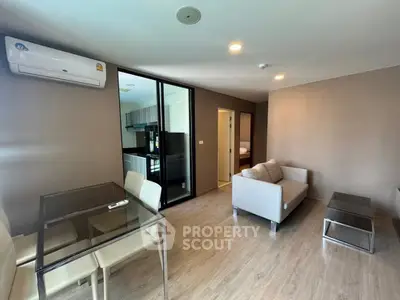Modern living room with glass dining table and cozy sofa in open layout apartment
