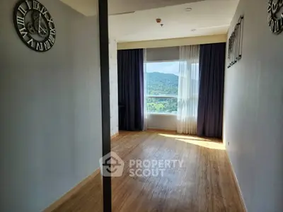 Spacious room with large window offering stunning mountain view, perfect for a serene living experience.