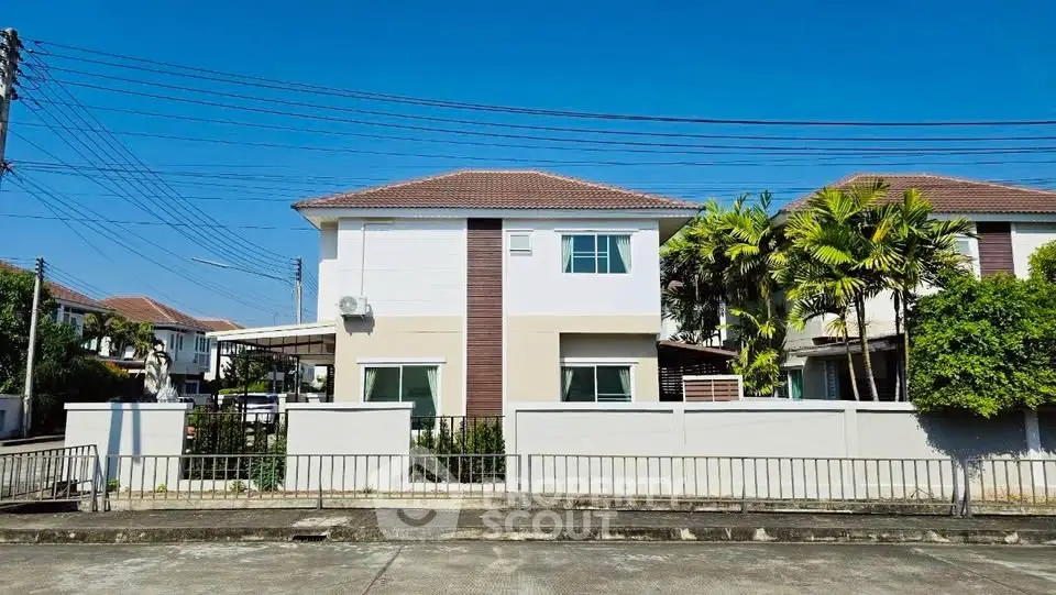 Charming two-story house with modern design and lush greenery in a serene neighborhood.