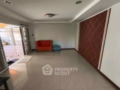 Spacious living room with tiled floor and unique wall design, perfect for customization.