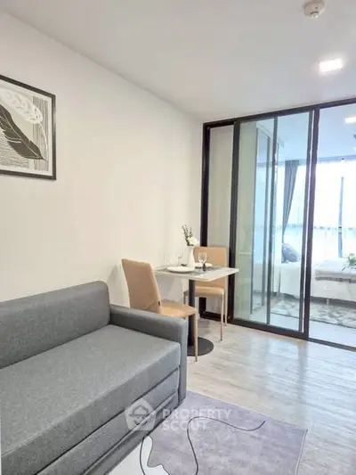 Modern living room with cozy sofa and dining area in open layout apartment.