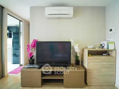 Modern living room with TV and air conditioning, featuring sleek furniture and bright decor.
