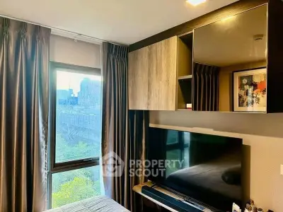 Modern bedroom with large window and sleek TV setup, offering a cozy and stylish living space.