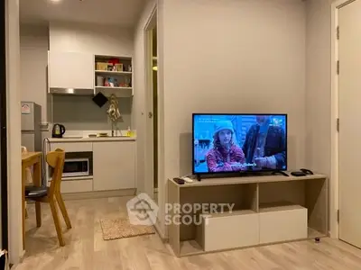 Modern apartment interior with cozy living room and compact kitchen, featuring wooden flooring and stylish furniture.