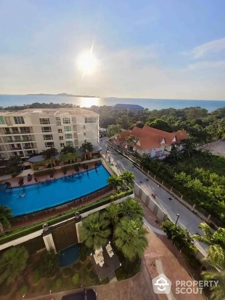 Stunning aerial view of luxury apartment complex with pool and ocean backdrop