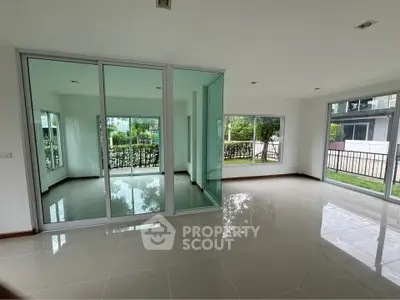 Spacious modern living room with large windows and garden view, perfect for natural light lovers.