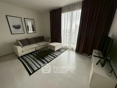 Modern living room with sleek decor and large window offering natural light.