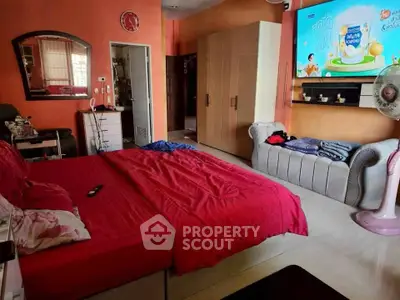 Spacious bedroom with vibrant red bedding and modern furnishings