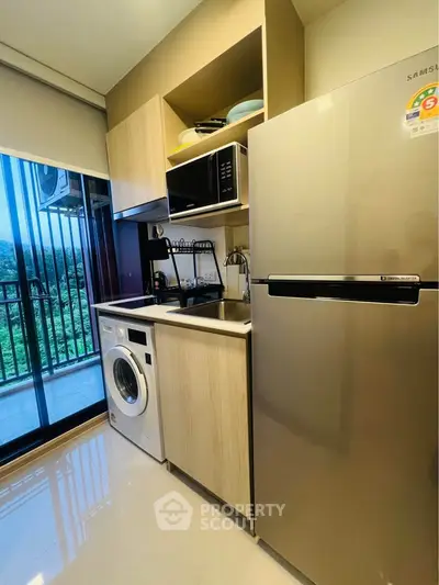 Modern kitchen with sleek appliances and balcony view in stylish apartment