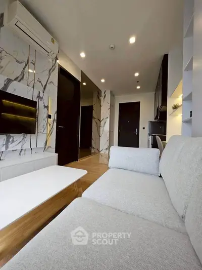 Modern living room with stylish marble accents and cozy seating in a contemporary apartment.