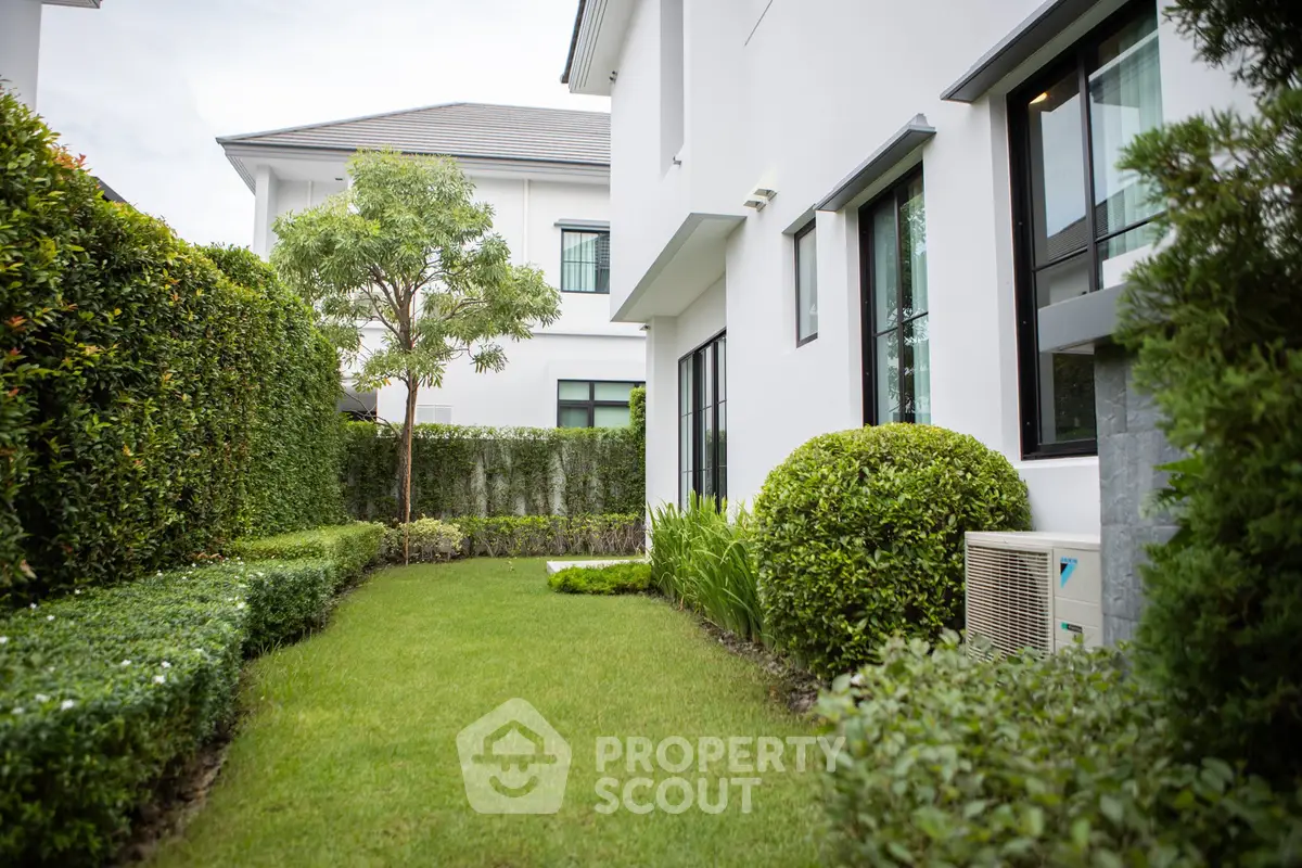 Charming garden view of modern home with lush greenery and sleek architecture.