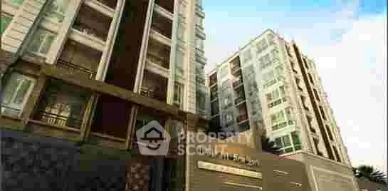 Modern high-rise apartment building with glass balconies and urban design.