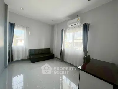 Spacious living room with modern sofa and air conditioning, perfect for relaxation.