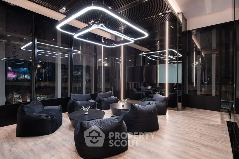 Modern lounge area with sleek lighting and plush seating in a high-end building.