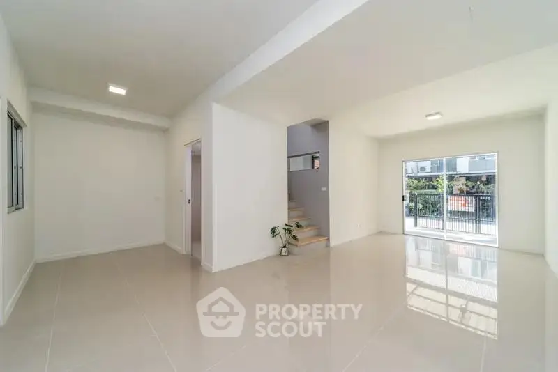 Spacious modern living room with glossy tile flooring and natural light