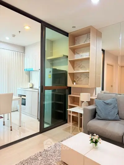 Modern open-layout living room with stylish kitchen and cozy seating area in a contemporary apartment.