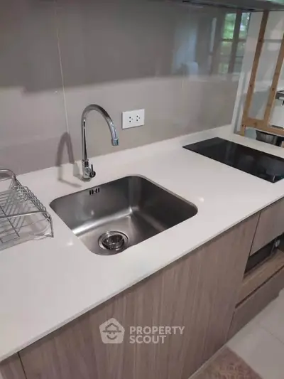 Modern kitchen with sleek countertop and built-in appliances in a stylish apartment.