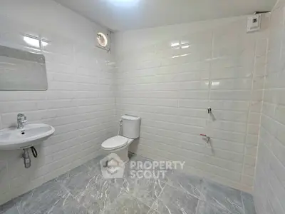 Spacious modern bathroom with sleek tiles and minimalist fixtures.