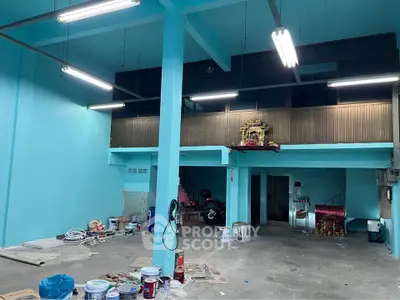 Spacious industrial-style interior with high ceilings and mezzanine, ideal for creative workspace or studio.