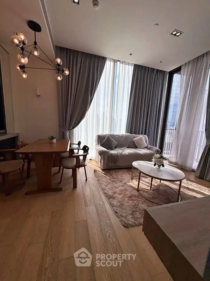 Elegant living room with modern furniture and large windows offering natural light.