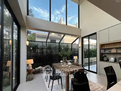 Stunning modern dining area with high ceilings and large windows, perfect for entertaining.
