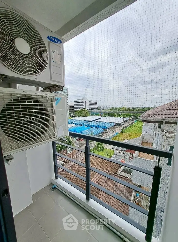 Charming balcony with city view and air conditioning unit, perfect for relaxation.