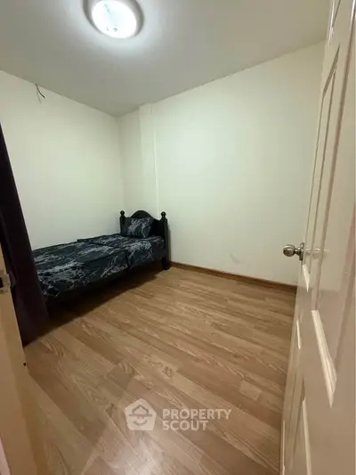 Cozy small bedroom with wooden flooring and single bed