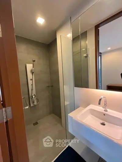 Modern bathroom with sleek shower and stylish sink in contemporary apartment.
