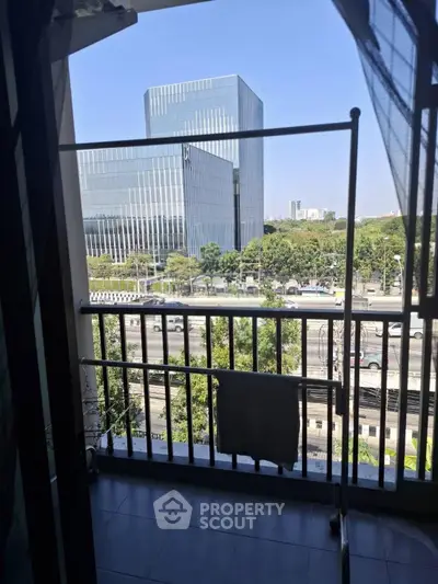 Modern balcony with city view and sleek glass buildings in the background.