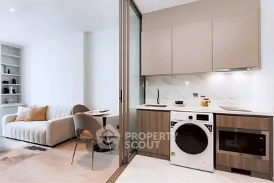 Modern open-plan kitchen and living area with sleek appliances and stylish furniture.
