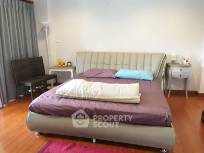 Cozy bedroom with modern bed and wooden flooring, perfect for relaxation.