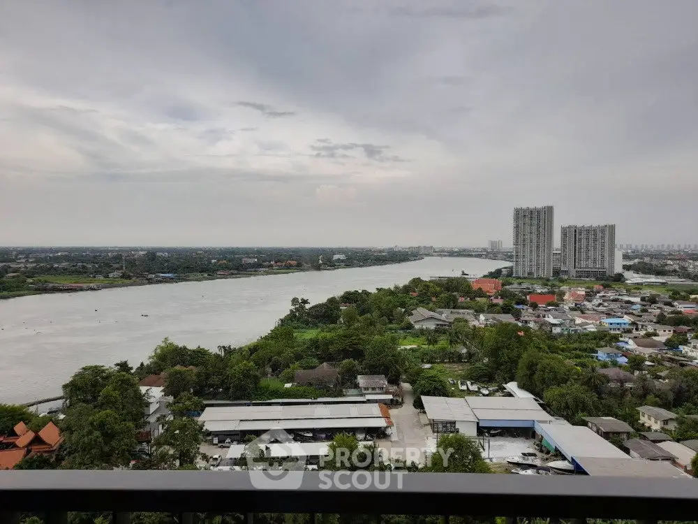 Stunning river view from high-rise balcony overlooking cityscape and lush greenery.